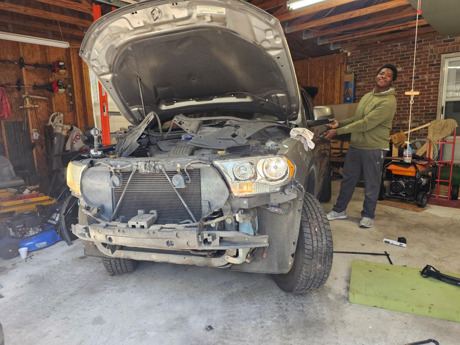 D'Onthony Johnson working under the hood of an SUV in a garage