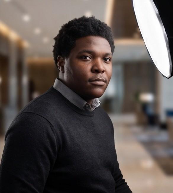 D'Onthony Johnson in a black sweater, photographed in an office lobby